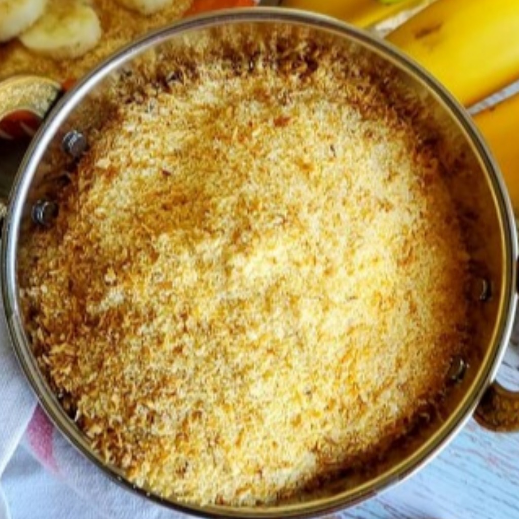 A bowl of avalose powder sits next to a small banana.